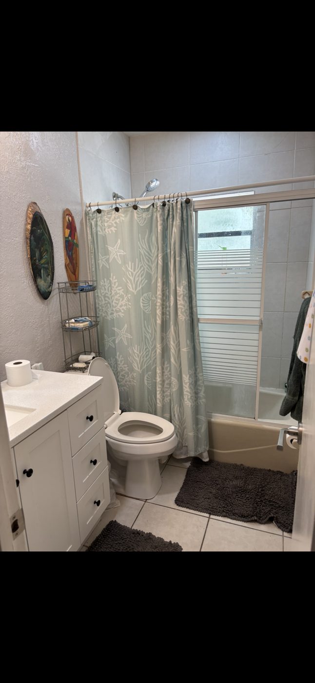 Before: original Fort Lauderdale Beach bathroom with tub and shower curtain